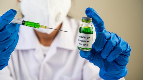 Scientists wearing masks and gloves Holding a syringe with a vaccine to prevent covid-19